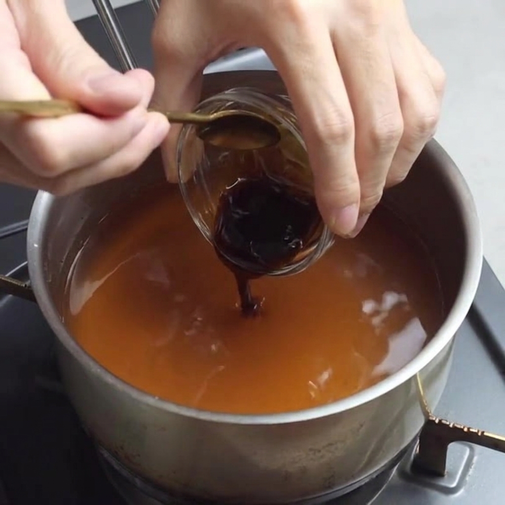 Austernsauce wird in die Ramen-Brühemischung gegeben.