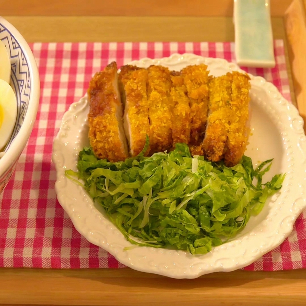 Das Hähnchenschnitzel wird fest in eine Schicht aus Panko-Paniermehl gedrückt.