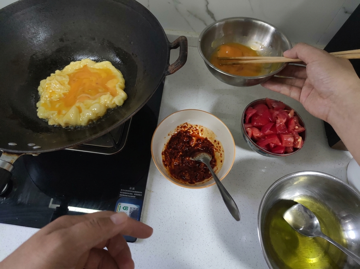 Eier werden in einem heißen Wok fluffig und goldgelb gebraten.