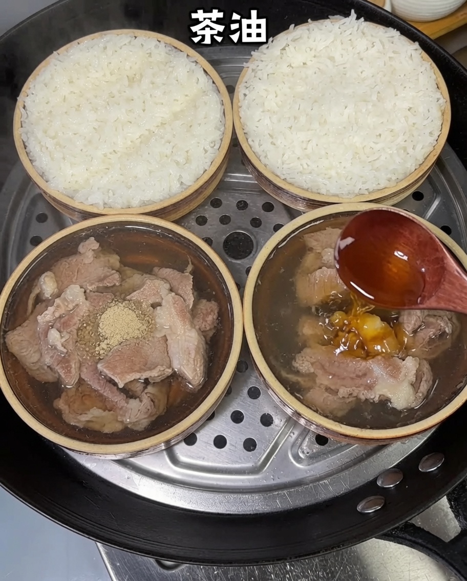 Teeöl wird mit einem Holzlöffel über die gedämpften Schweinefleisch-Reis-Schüsseln geträufelt.