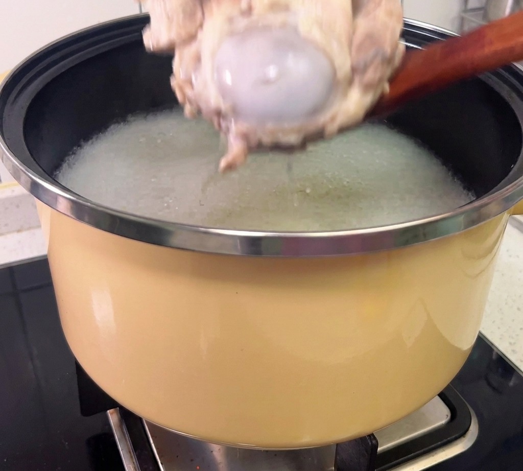 Fleisch wird mit Handschuhen von den gegarten Knochen gelöst.