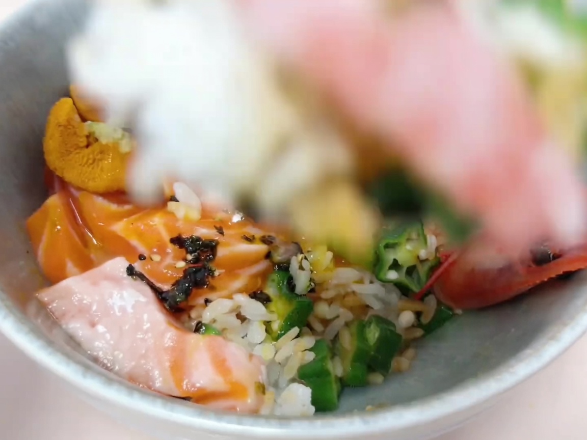Zutaten, die vorsichtig auf dem Reis arrangiert werden, um die Donburi-Basis zu bilden.