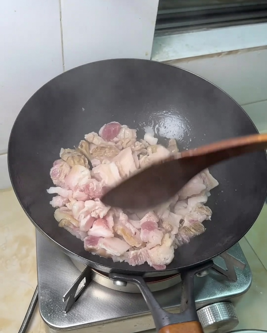 Dünne Scheiben Schweinebauch in einer heißen Pfanne.