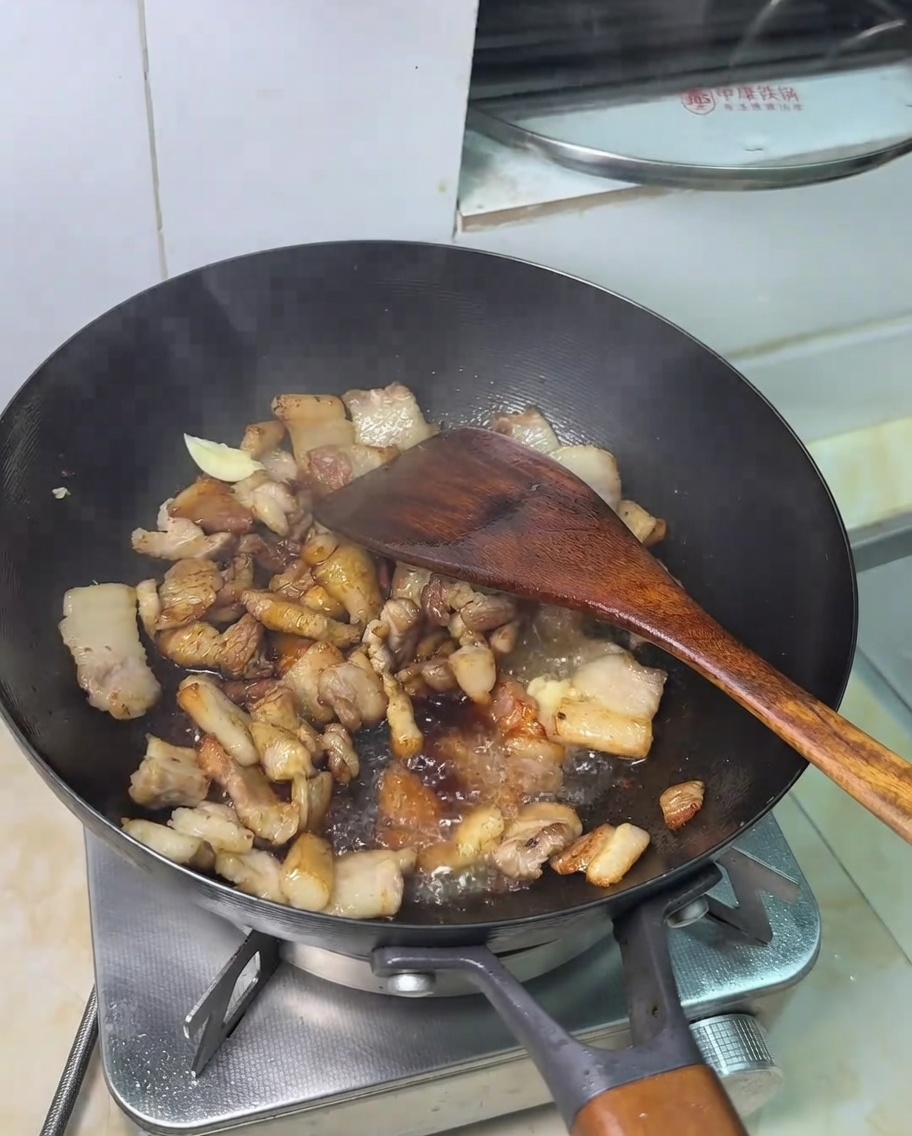 Ein Löffel Zucker wird zur Schweinefleisch-Sojasaucen-Mischung gegeben.