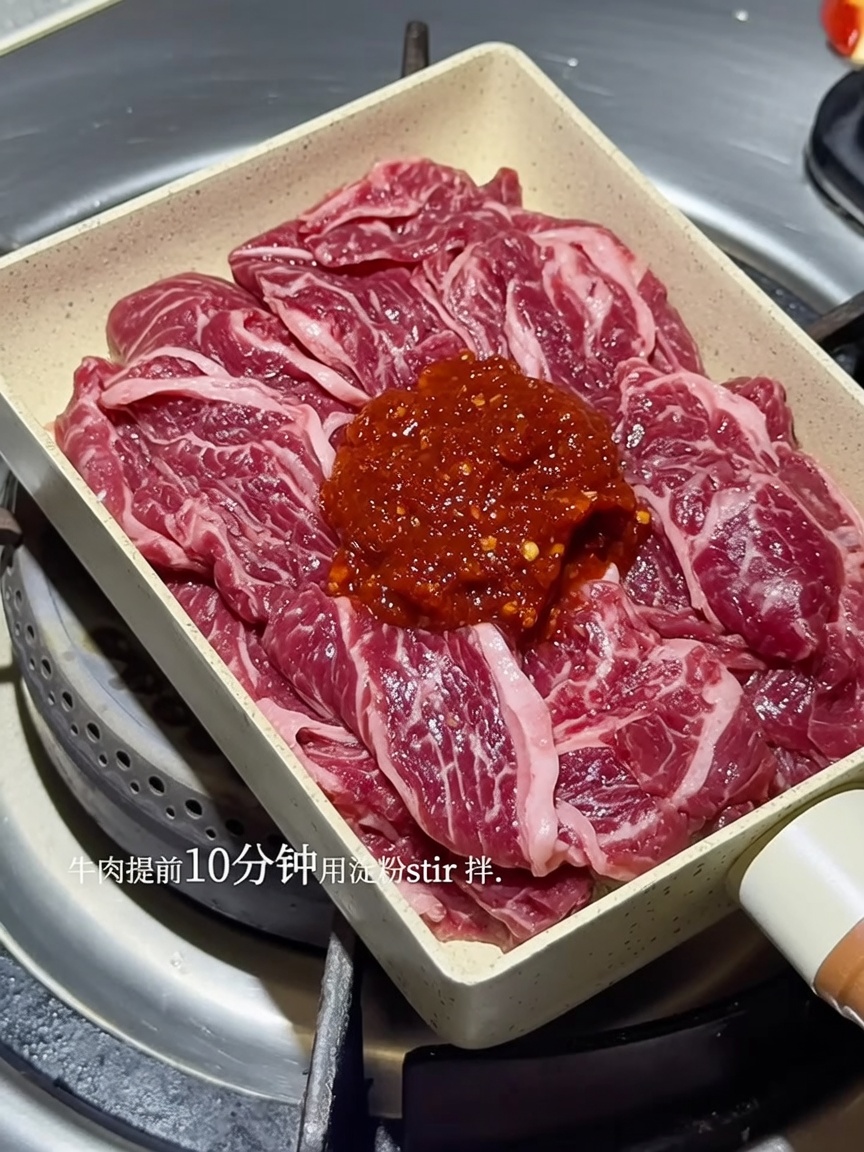 In der Pfanne brutzelnde Rindfleischstreifen in roter koreanischer Soße.