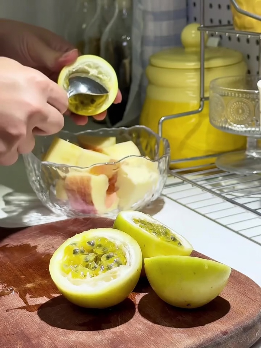 Passionsfruchtmark wird über Apfelspalten in einer Glasschüssel gegeben.