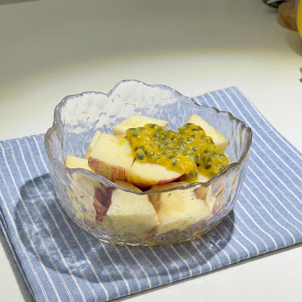 Schüssel mit gewürfelten Äpfeln, getoppt mit Passionsfruchtmark und Honig.