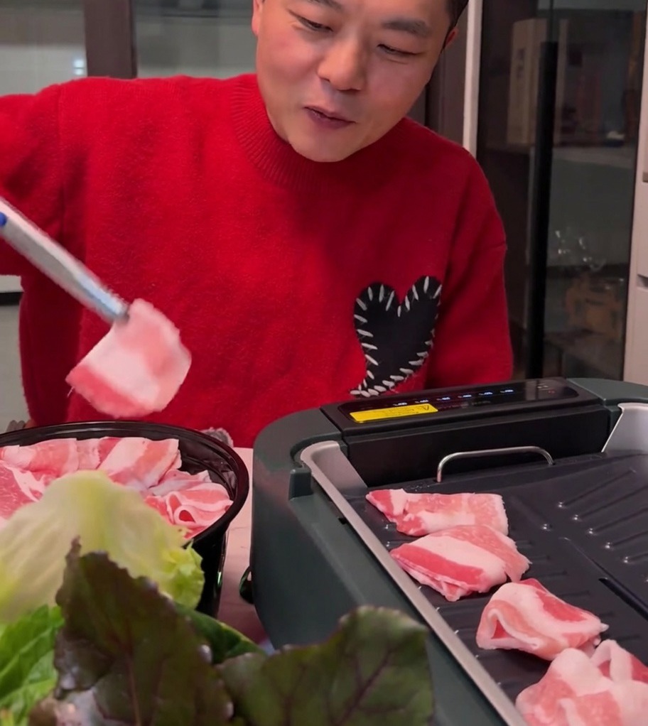 Dünne Schweinebauchscheiben garen auf einem heißen Elektrogrill und werden goldbraun.
