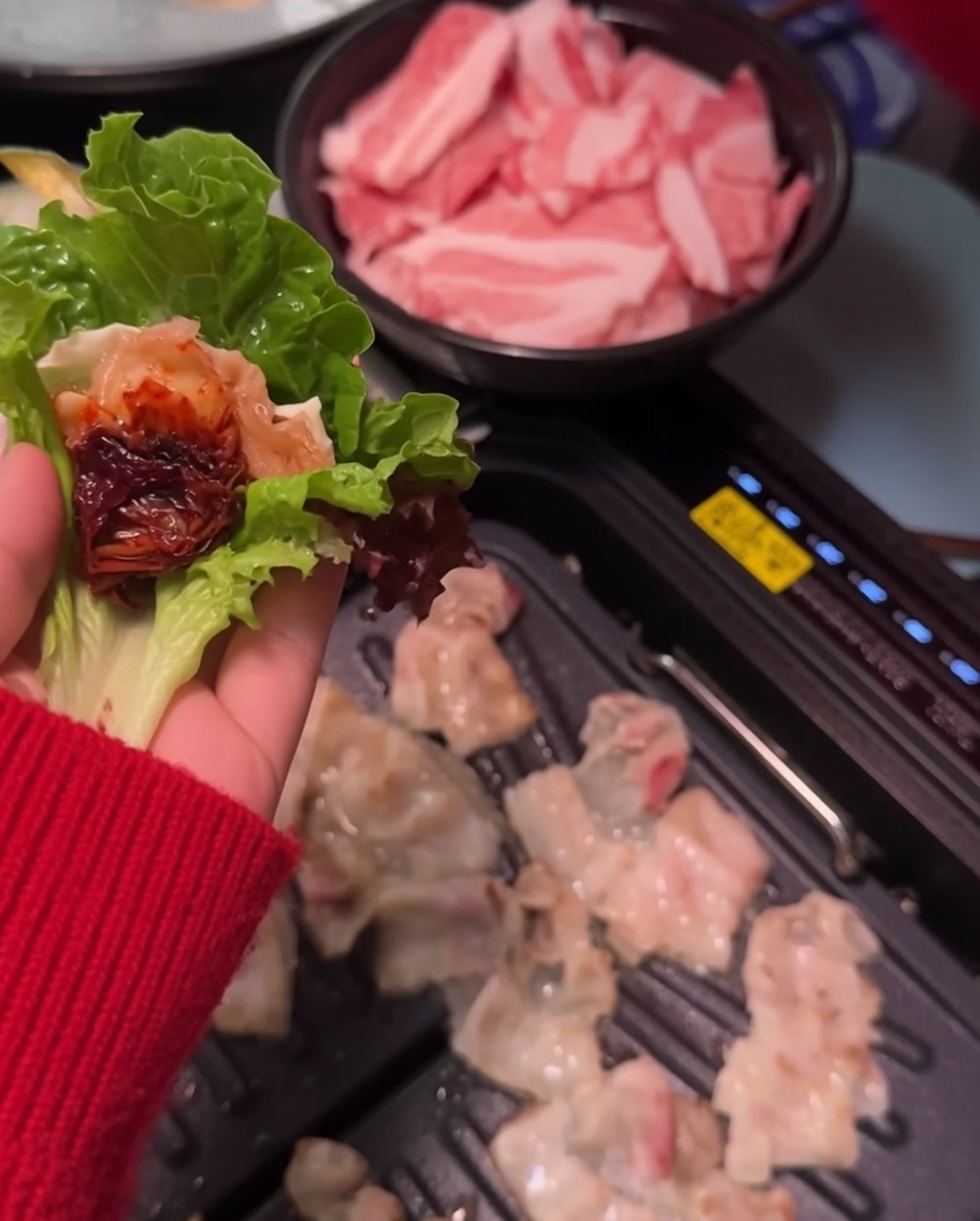 Würzige Sojabohnenpaste wird auf eine Schweinebauchscheibe auf einem Blatt aufgetragen.