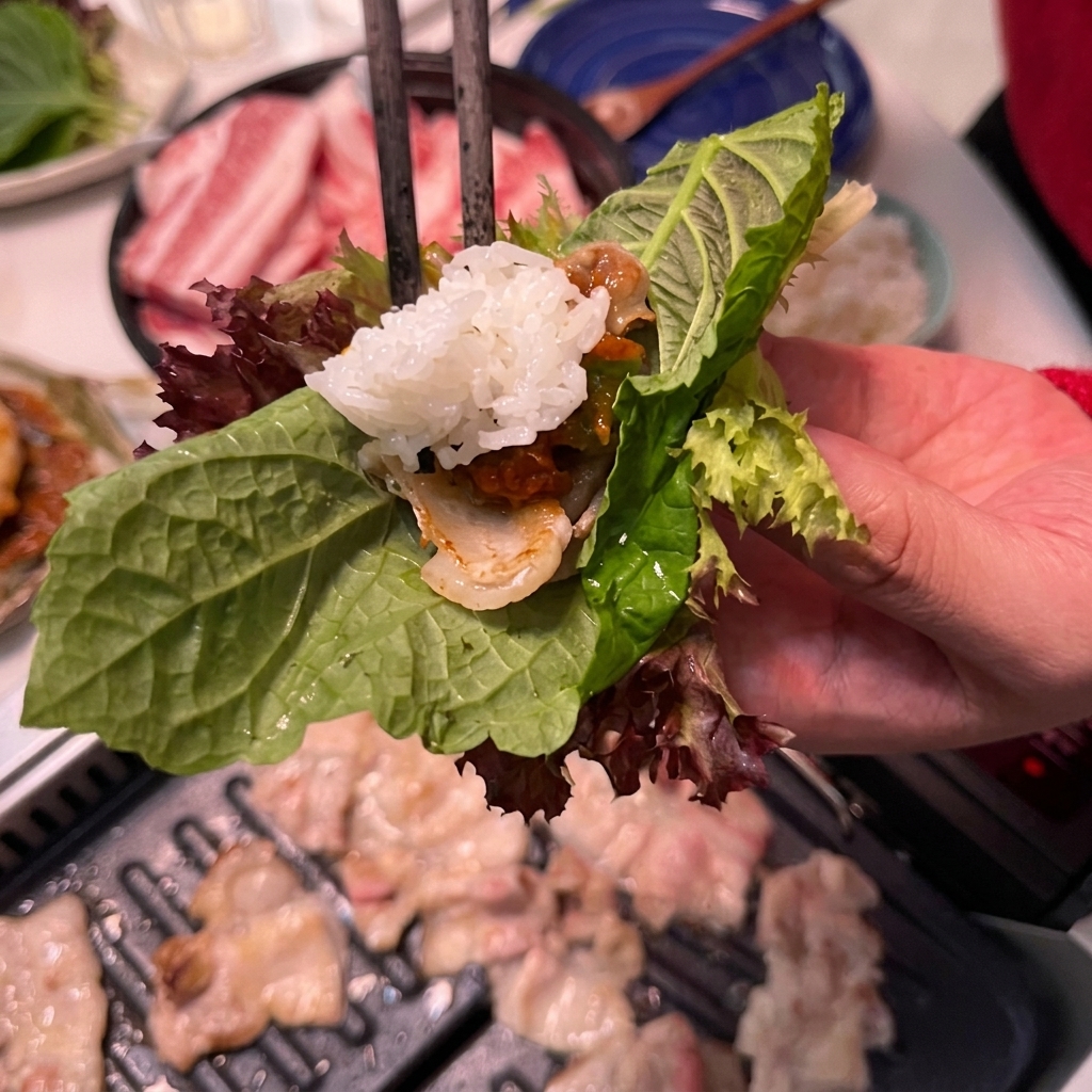 Ein Löffel weißer Reis wird zu einem Salat-Wrap mit Fleisch und Sauce hinzugefügt.