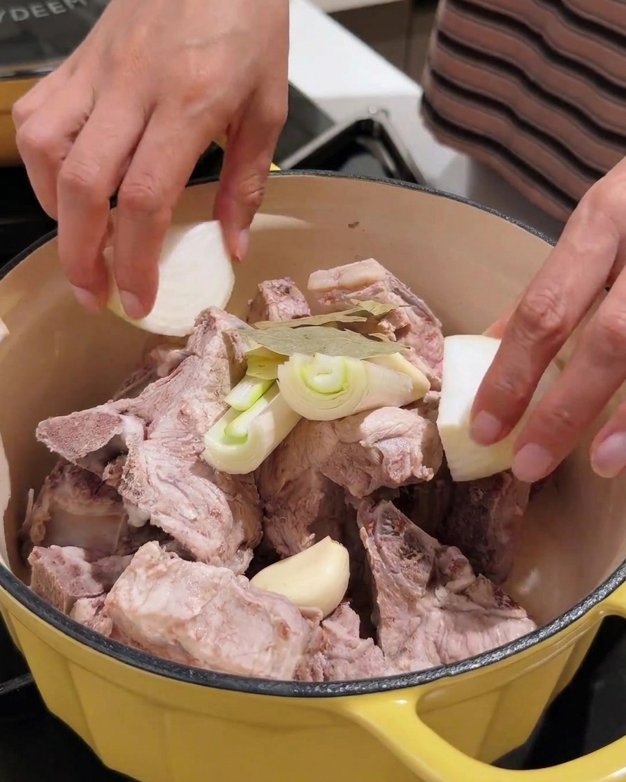 Knoblauch, Zwiebeln und Sojabohnenpaste werden zum Fleisch gegeben.