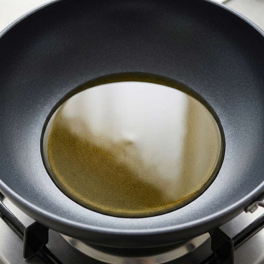 Goldenes Öl in einer Pfanne mit Eiern, die gerade gebraten werden.