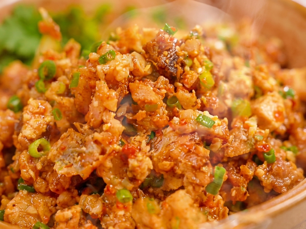 Ein Löffel mit der gewürzten Fleisch-Ei-Füllung wird auf die Mitte eines runden Dumpling-Teigblatts zum Verschließen gelegt.