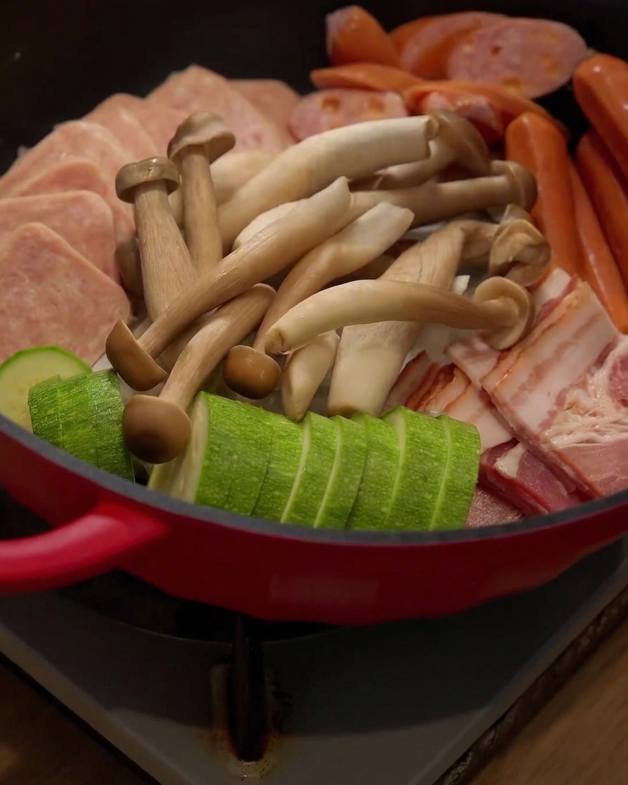 Frische Enoki-Pilze werden in die Anordnung des Hot Pots gegeben.