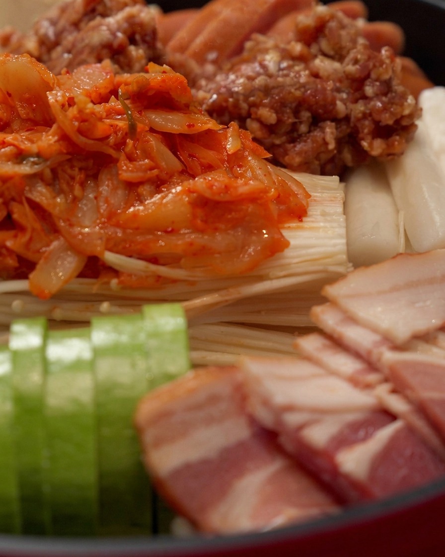 Scharfe rote Hot-Pot-Sauce wird gleichmäßig über die angeordneten Zutaten gegossen.