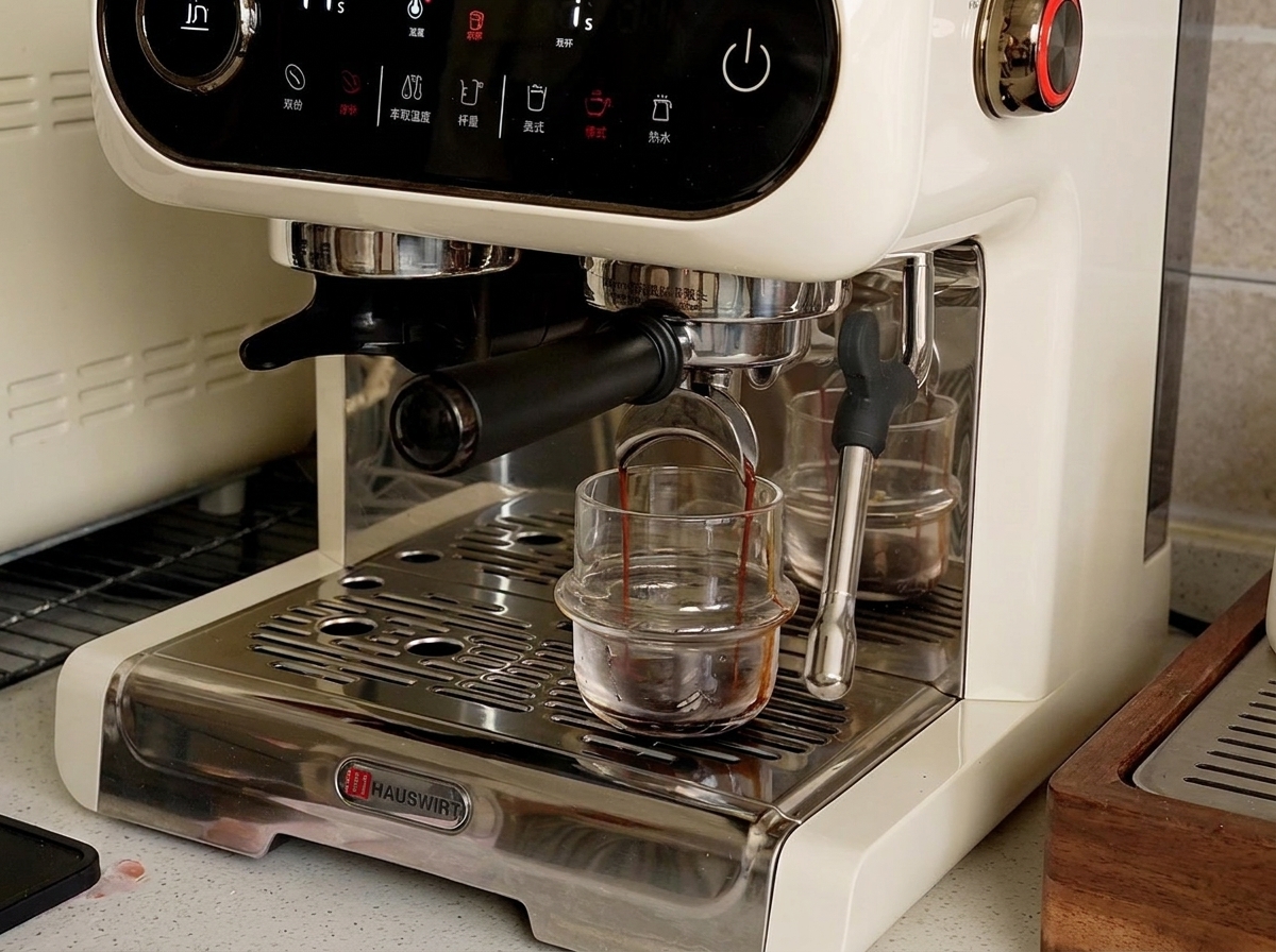 Eine Espressomaschine gibt dunklen, flüssigen Espresso in eine kleine Tasse auf der Abtropfschale ab.