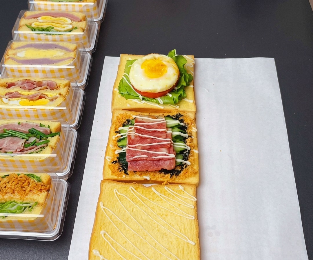 Die zusammengesetzten Sandwich-Schichten mit süßem Salatdressing, Ketchup auf dem Ei und Honig-Senf-Sauce auf dem Speck.