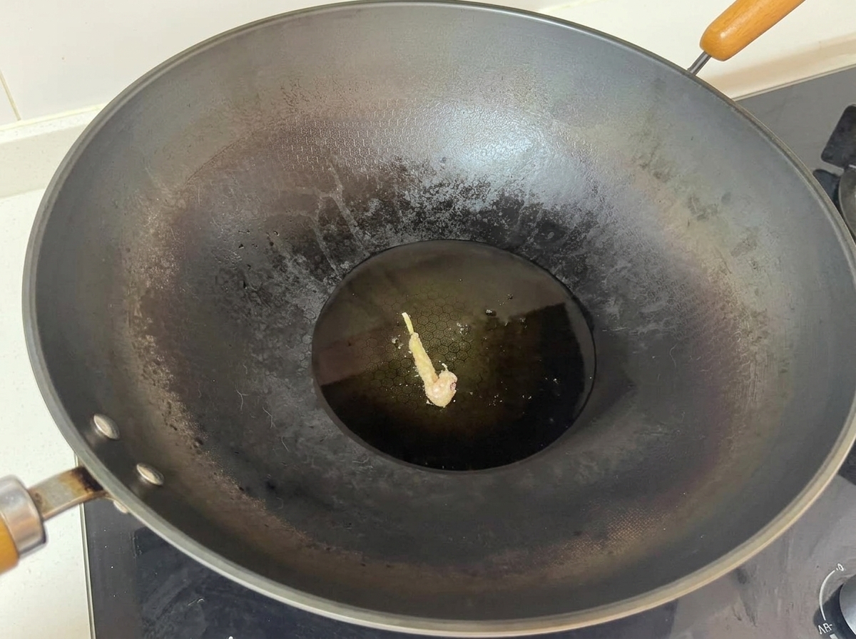 Ein einzelnes paniertes Hähnchenstück brüht in der Mitte eines großen Woks mit heißem Öl.