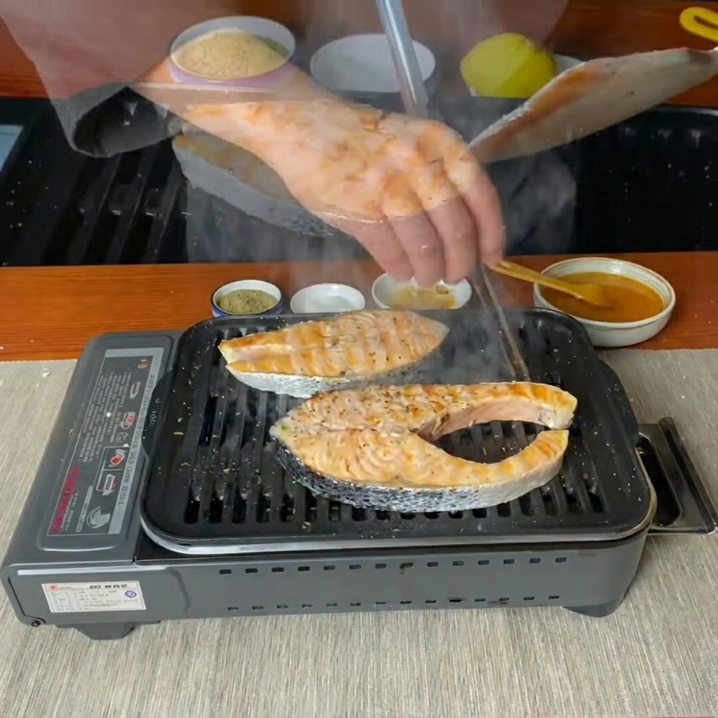 Lachssteaks werden mit einem Pfannenwender auf einer heißen Grillpfanne gewendet.