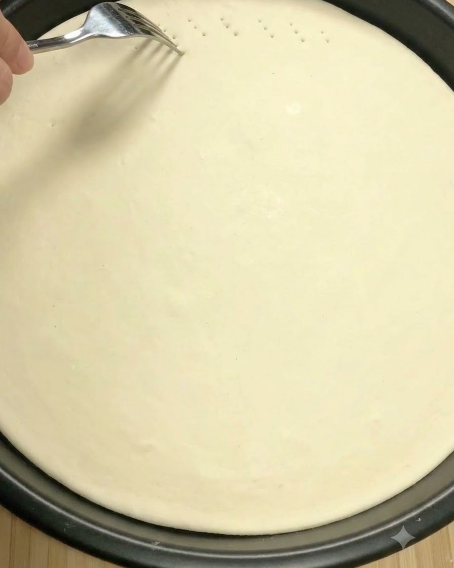 Eine Kuchengabel sticht kleine Löcher in die Oberfläche des rohen Pizzateigs.