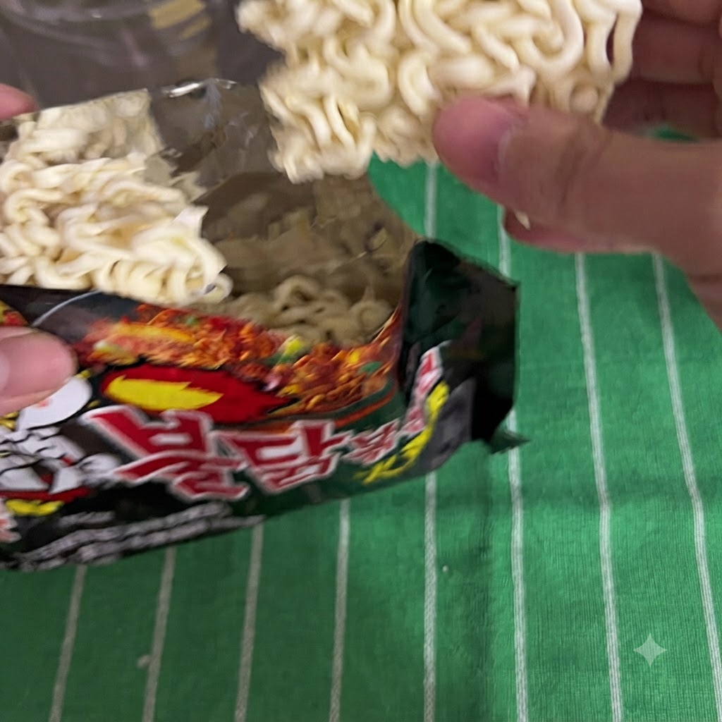 Instant-Nudeln werden aus einer schwarzen Verpackung genommen.