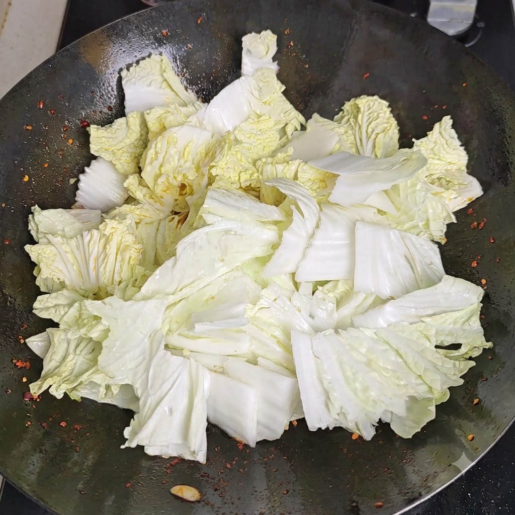 Essig wird entlang des erhitzten Umfangs des Wok gegossen und reagiert mit der heissen Oberfläche.