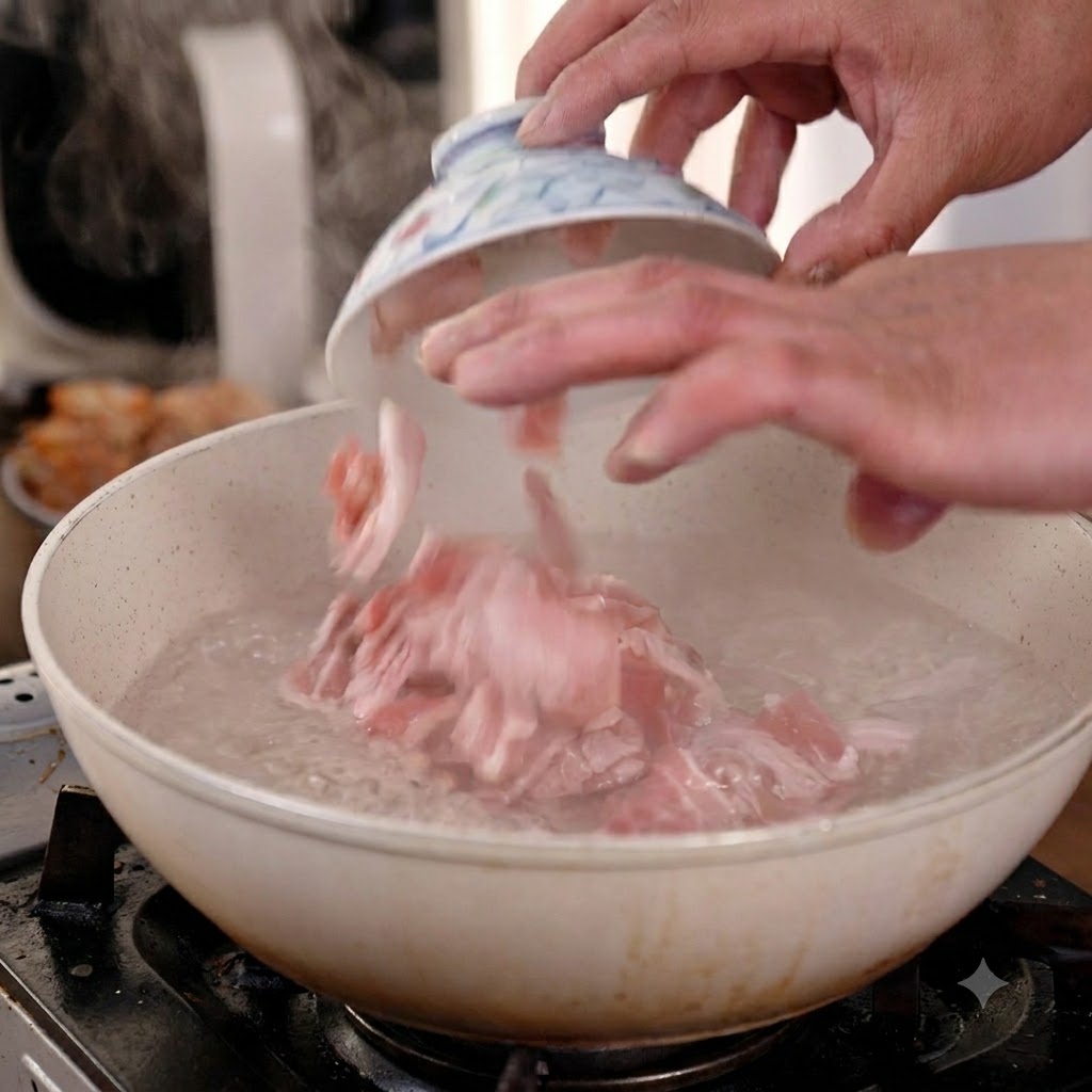 Hände geben rohe Schweinebauchscheiben in einen Topf mit kochendem Wasser.