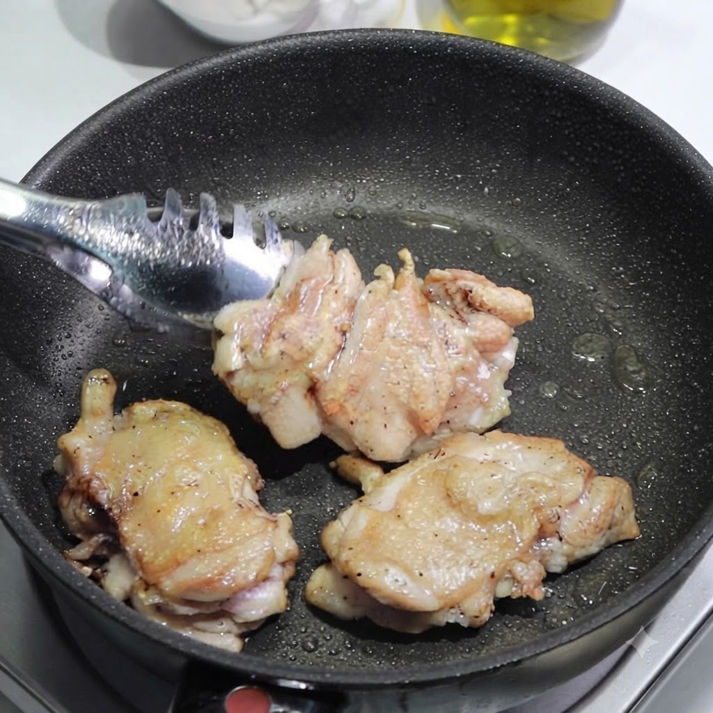 Eine Zange legt angebratene Hähnchenschenkel aus einer Pfanne zum Schneiden auf ein Schneidebrett.