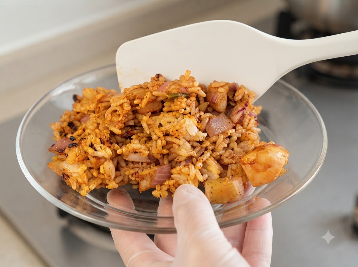 Gehackte rote Zwiebeln und minced Knoblauch werden in die Pfanne zum Hähnchen gegeben.
