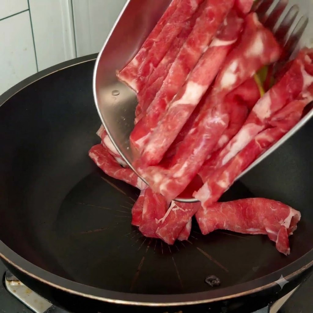 Rohe Rindfleischscheiben werden von einem Metalltablett mit Kochutensilien in eine schwarze Pfanne gegeben.