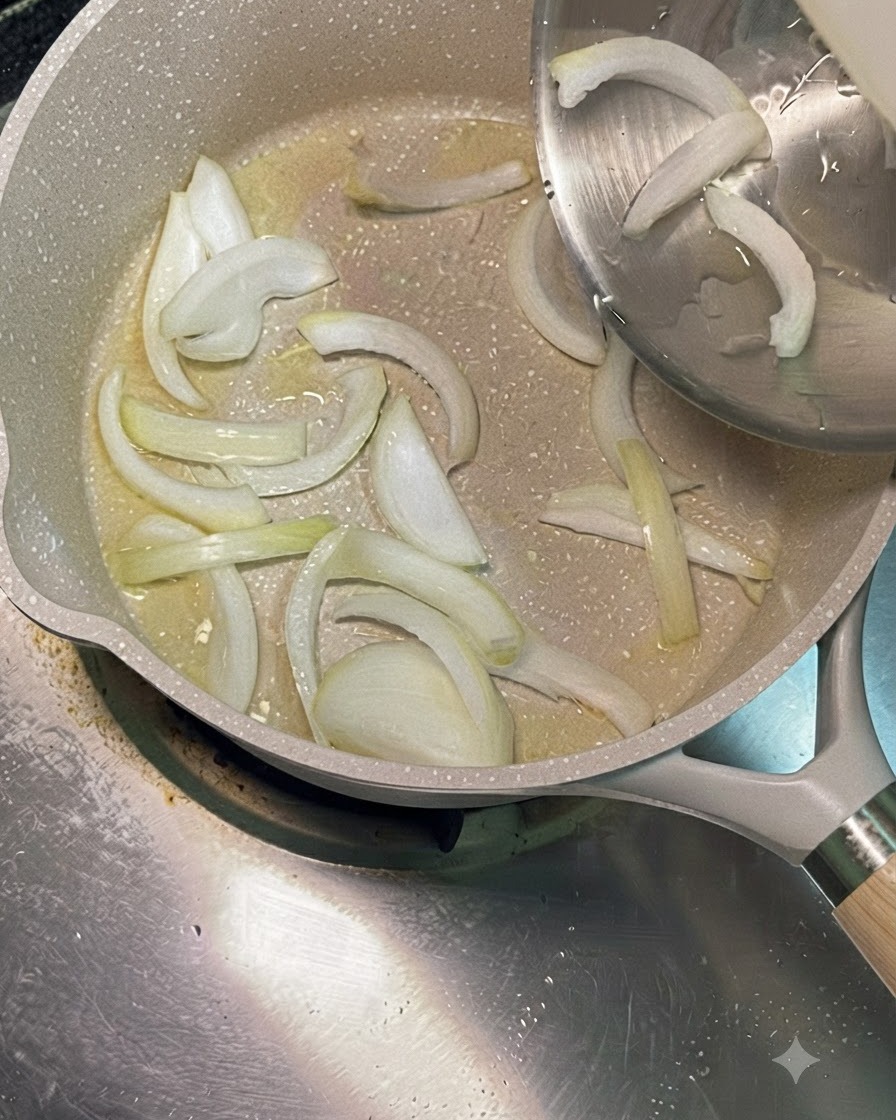 In Scheiben geschnittene weiße Zwiebeln werden aus einer Edelstahlschüssel in eine heiße Pfanne mit Speiseöl gegeben.