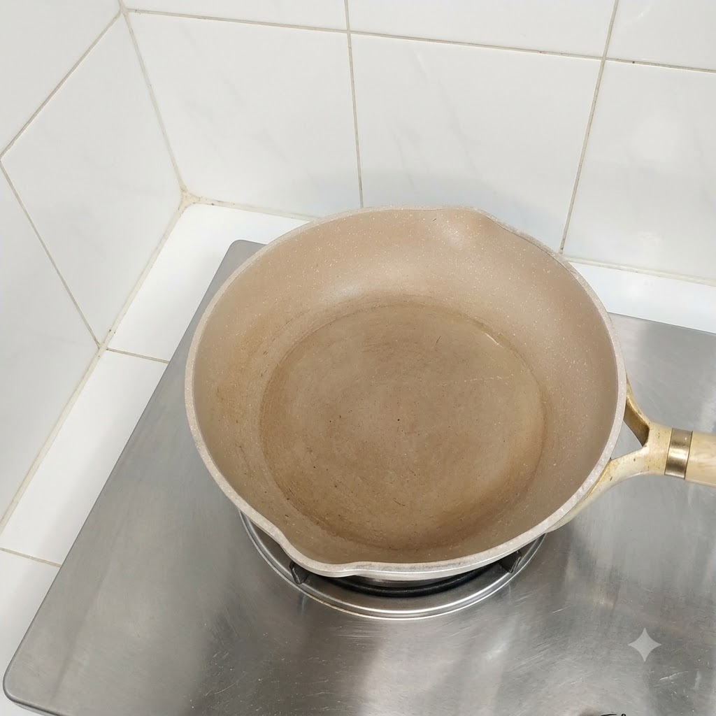 Eine leere, eingeölte Pfanne steht auf einem Herd und ist bereit zum Kochen.