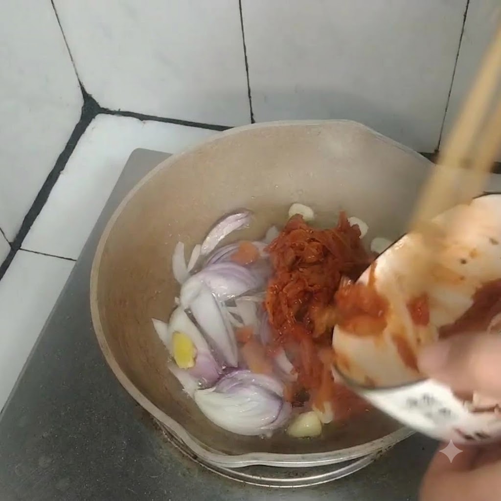 Kimchi wird aus einer kleinen Schüssel in eine Pfanne mit sautierten Zwiebeln, Knoblauch und Ingwer gegossen.