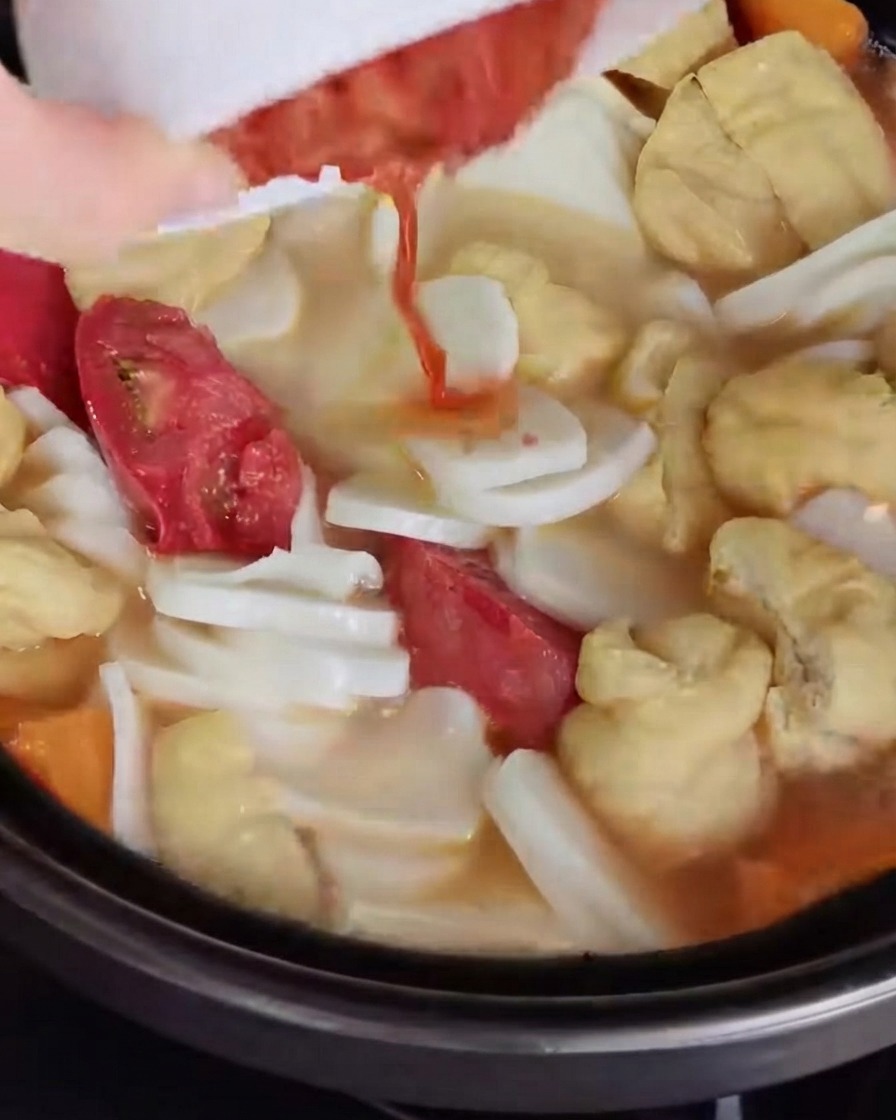 Gehacktes Kimchi wird in die Suppenbrühe gegossen und untergemischt.