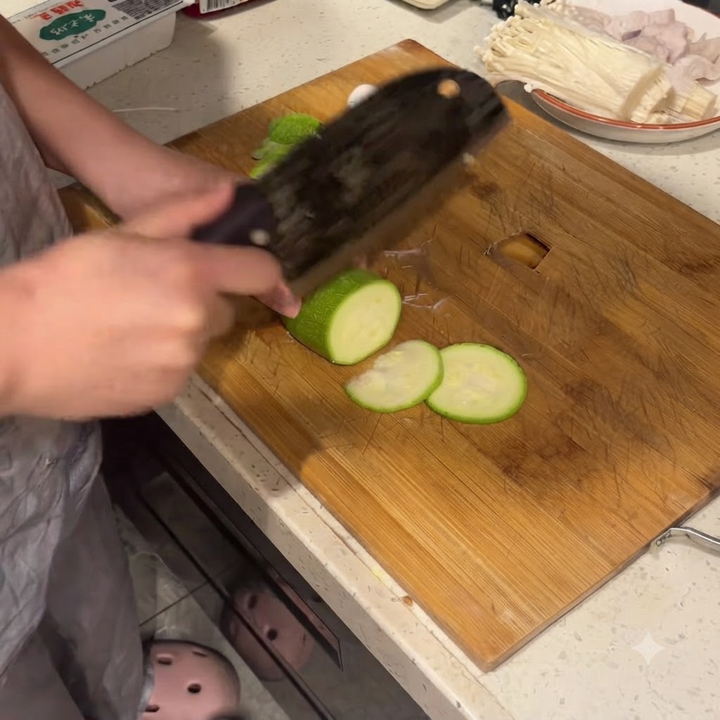 Zucchini wird auf einem Holzschneidebrett mit einem großen Beil in saubere Scheiben geschnitten.