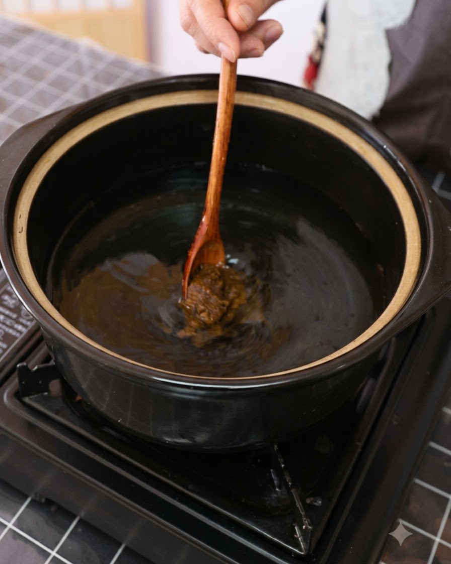 Braune Sojabohnenpaste wird mit einem Holzlöffel in einen Topf mit Wasser gerührt.