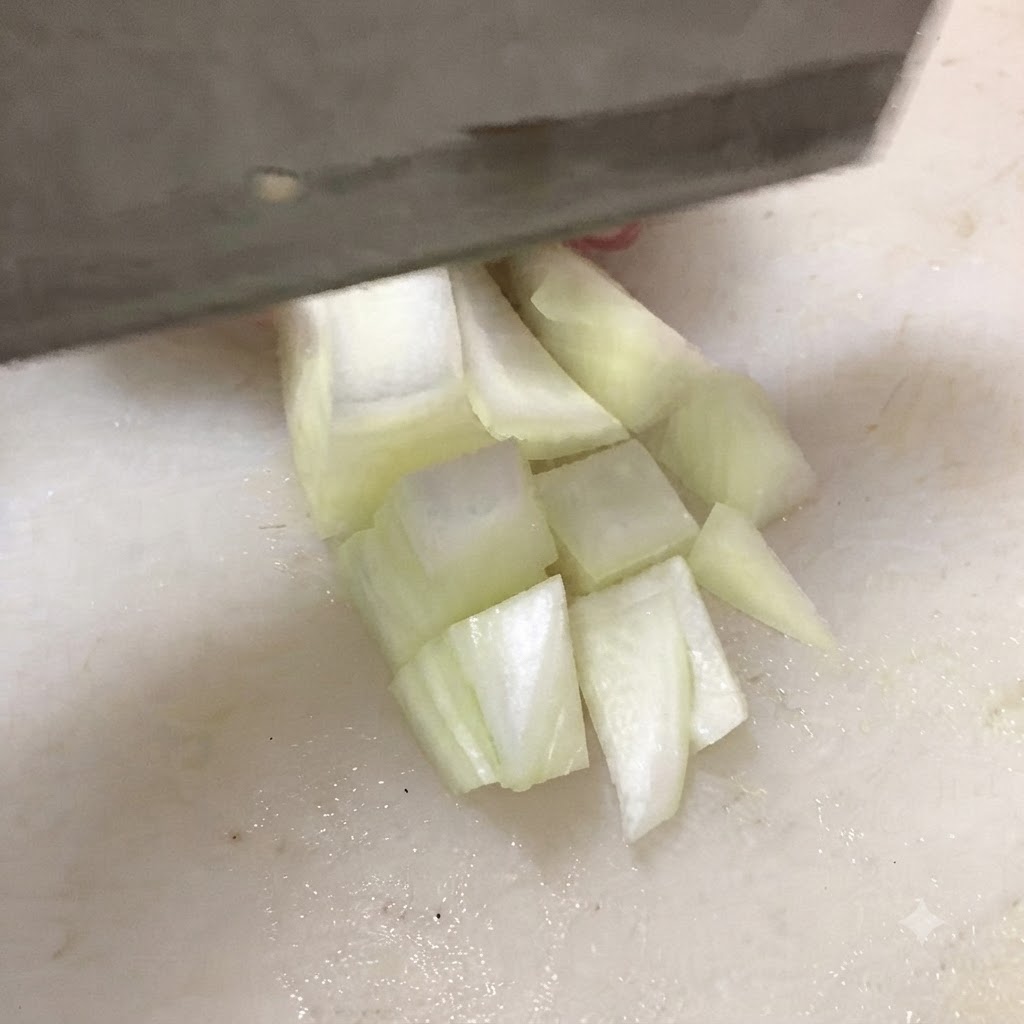 Ein Messer schneidet festen Tofu auf einem weißen Schneidebrett in dicke Würfel.