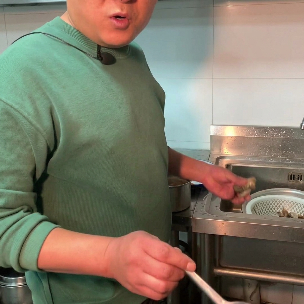 Frische Muscheln werden in einen Topf mit köchelndem Sojabohnenpasten-Eintopf gegeben.