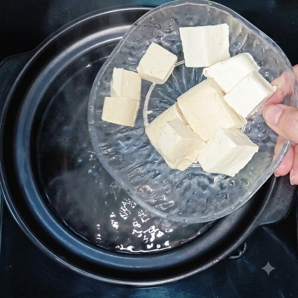 Tofuwürfel werden in einen Topf mit kochendem Wasser gegeben.
