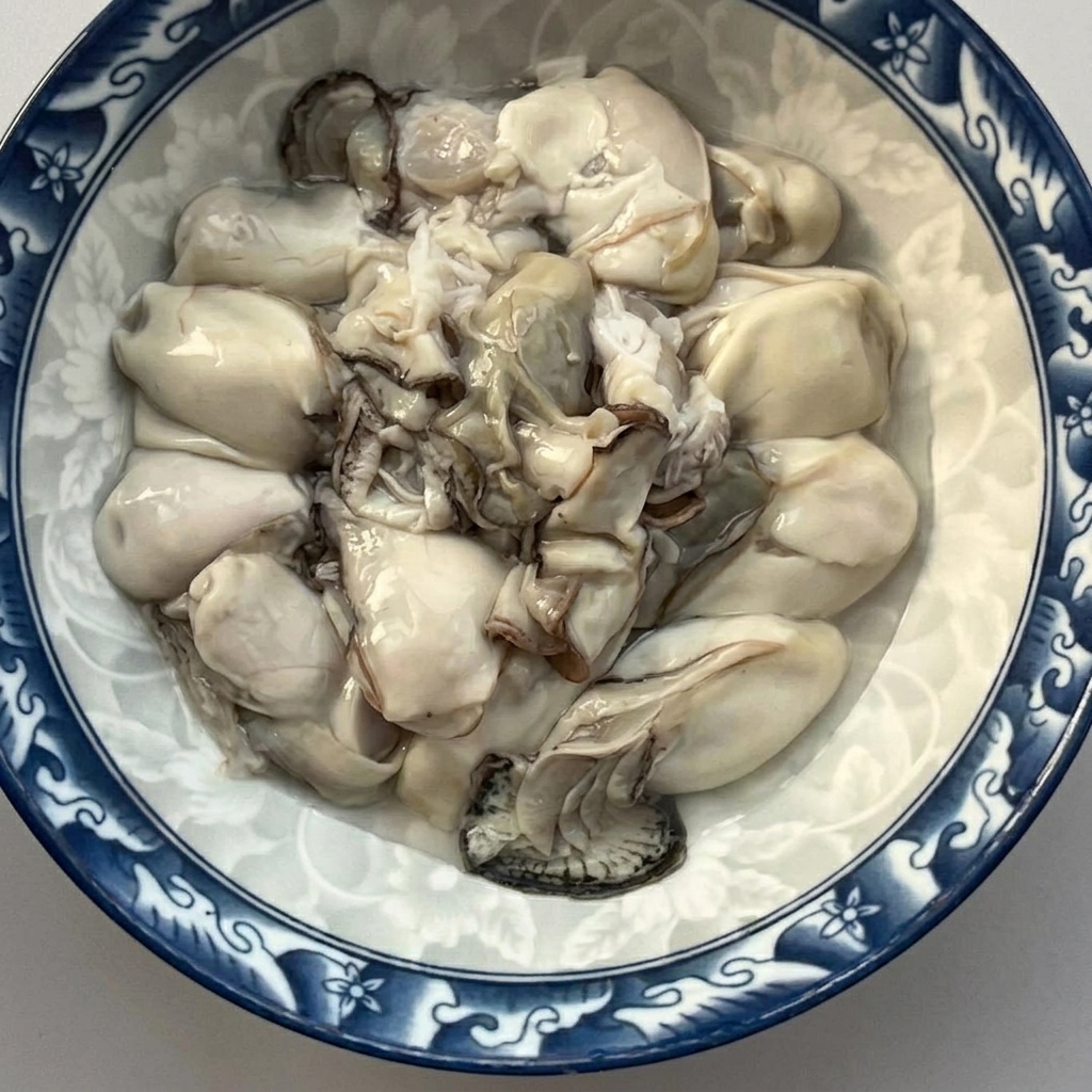 Eine Schüssel gefüllt mit frisch ausgelösten und abgespülten rohen Austern.