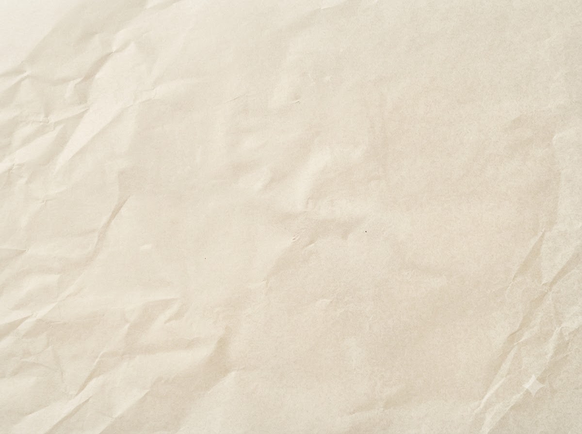 Geformte rohe Fleischpatties auf einem Bogen Backpapier.