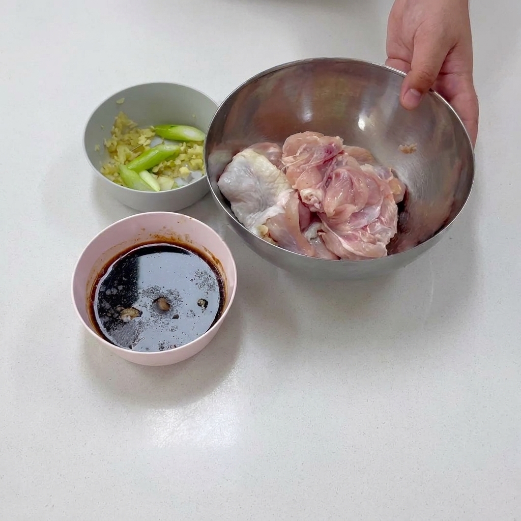Knochenloses Hähnchenkeulenfleisch liegt während der Vorbereitung in einer Edelstahlschüssel.