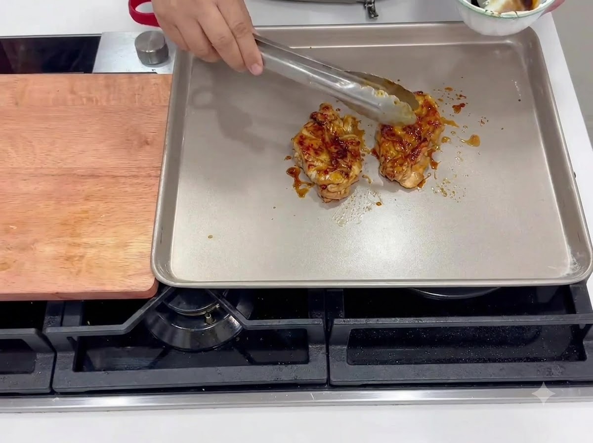 Marinierten Hähnchenschenkel braten mit der Hautseite nach unten in einer heißen eckigen Pfanne.
