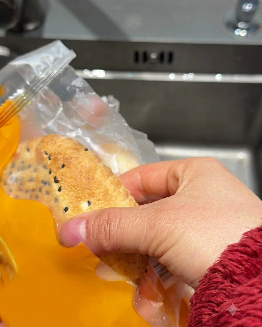 Gefrorene Burgerbrötchen werden in einer Spüle kurz unter fließendem Leitungswasser abgespült.