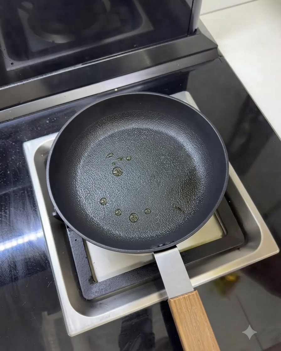 Eine Pfanne mit mehreren kleinen Sprühwassertropfen beziehungsweise Öltröpfchen auf der Oberfläche.