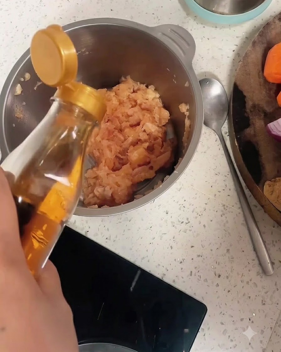 Kochwein wird aus einer Flasche in eine Edeltahlschüssel mit Hähnchenhackfleisch und Pfeffer gegossen.