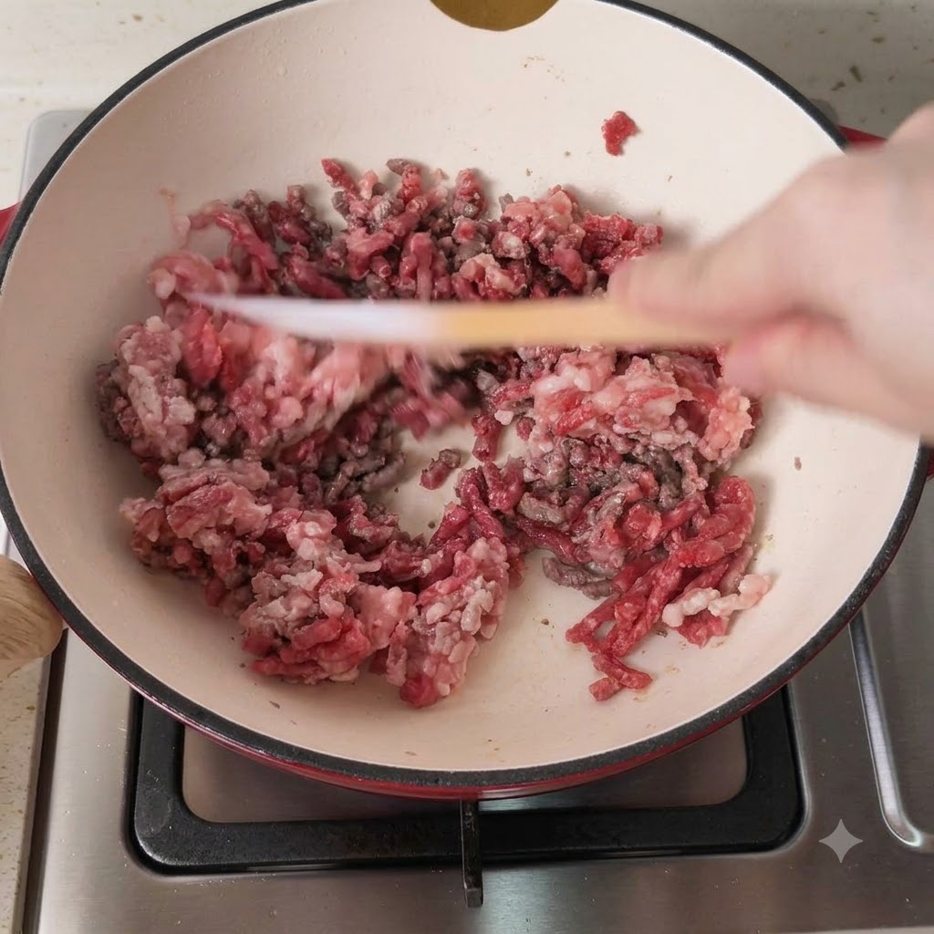 Schweine- und Rinderhackfleisch wird in einem heißen Kochtopf braun angebraten.