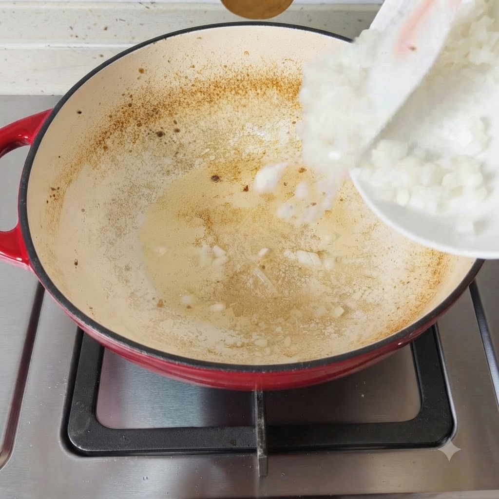 Gehackte Zwiebeln treffen auf die heiße, eingefettete Pfannenoberfläche.