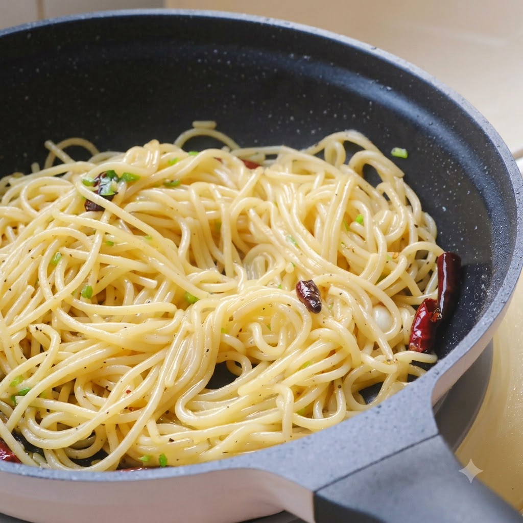 Frische gehackte Korianderblätter, Meersalz und schwarzer Pfeffer werden über die Pasta in der Pfanne gestreut.