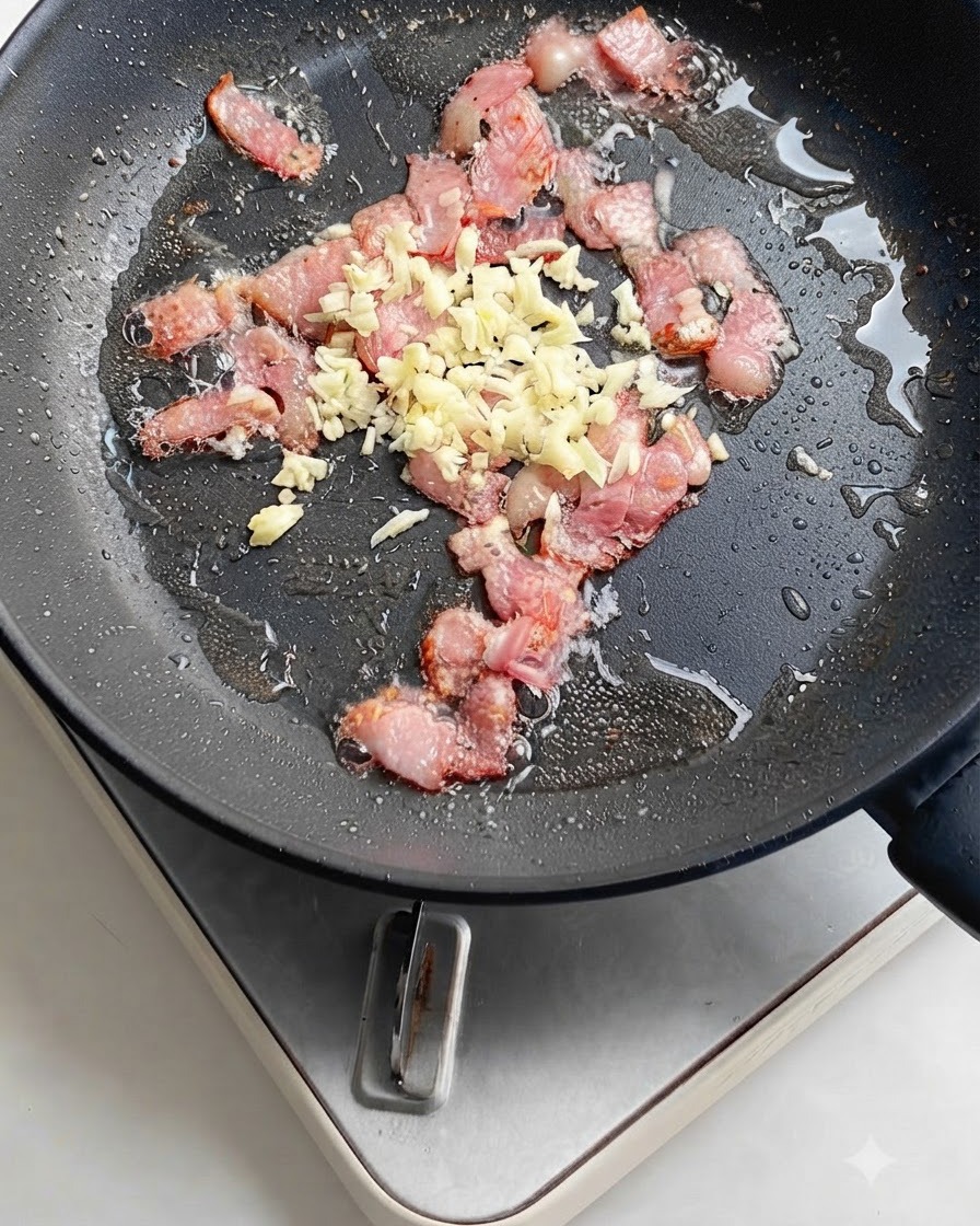 Helle rote Chilischotenscheiben werden in die Pfanne mit brutzelndem Speck und Knoblauch gegeben.